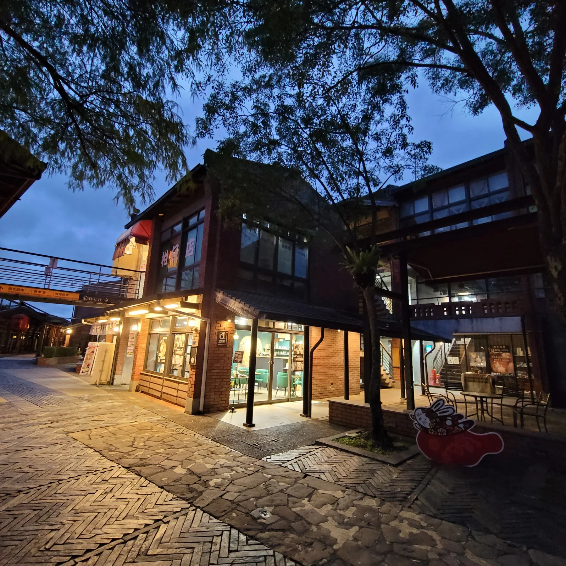 夜間紅磚建築外觀與店面室內透出的溫暖燈光