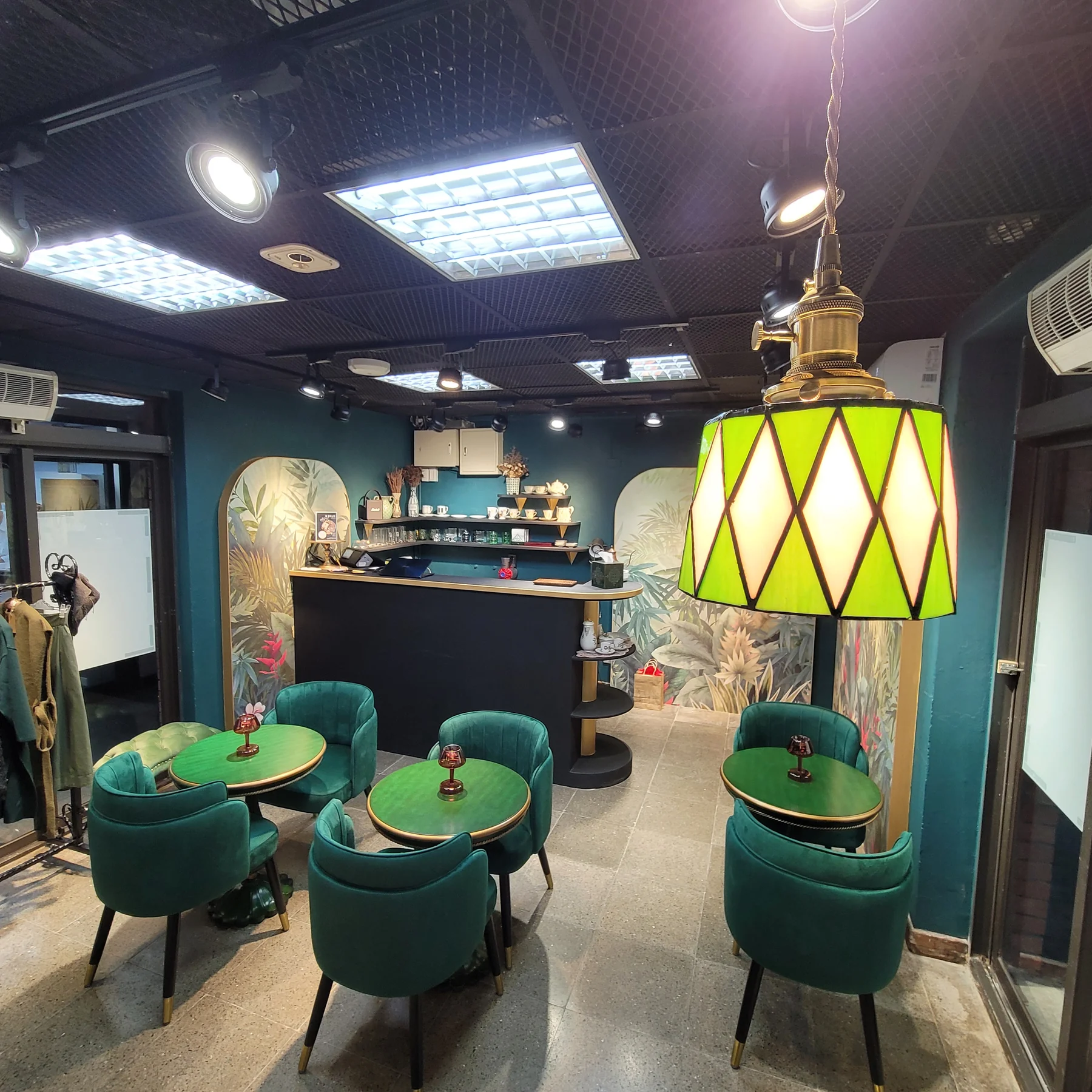 綠色玻璃與金色結構的復古吊燈懸掛在品牌店面中央
